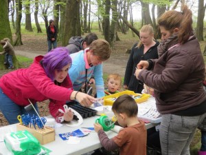 Women and children doing crafts at a table on a field